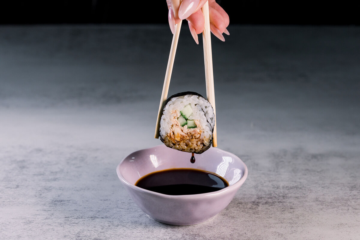 Sushi being dipped in soy sauce